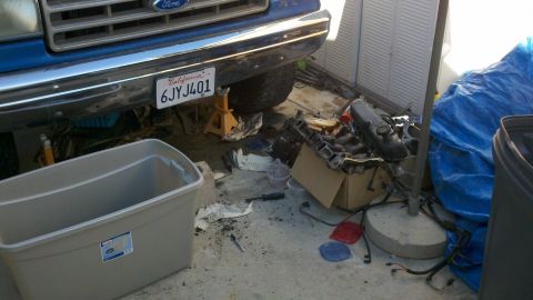 1990 Ford Bronco - Front view of a 1990 Ford Bronco undergoing repairs, with engine components visible.