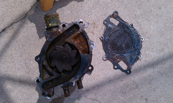 Rusty car water pump and gasket on concrete