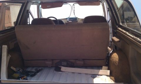 1990 Ford Bronco - The interior of a 1990 Ford Bronco, viewed from the rear cargo area, shows the back seat and dashboard.