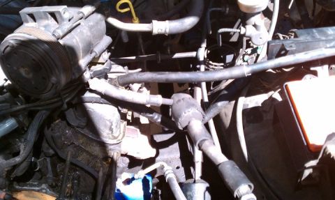 1990 Ford Bronco - Close-up view of a vehicle's engine bay, showing various components and hoses.