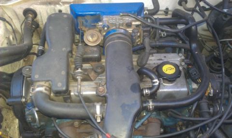 1991 Ford Festiva - Close-up view of a car's engine bay, showing various hoses, wires, and mechanical components.