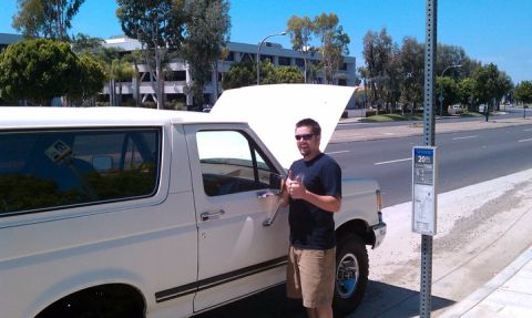 1990 Ford Bronco - A man gives a thumbs up next to a white 1990 Ford Bronco with its hood open.