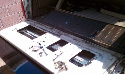 1990 Ford Bronco - The inside of a vehicle's tailgate is shown with tools laid out, suggesting a repair or modification is in progress.