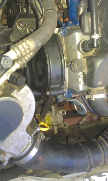 1991 Ford Festiva - A close-up view of various engine components, including hoses and a pulley system.