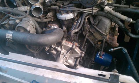 1990 Ford Bronco - Close-up view of a vehicle's engine bay, showing various components and hoses.