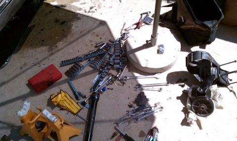 1990 Ford Bronco - Tools and equipment laid out on the ground for a vehicle repair project.