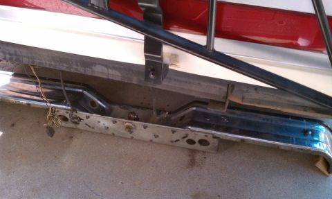 1990 Ford Bronco - Close-up of a vehicle's rear bumper and taillight assembly, showing exposed wiring and signs of wear.