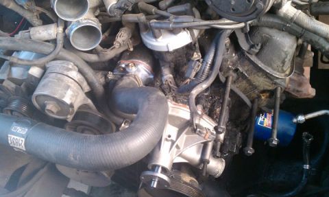 1990 Ford Bronco - Close-up of an engine bay, focusing on the water pump and associated components.