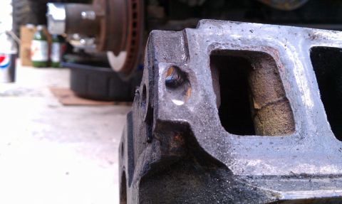 1990 Ford Bronco - A close-up view of a cast iron engine manifold, with a Supermotors.net watermark visible at the bottom right.