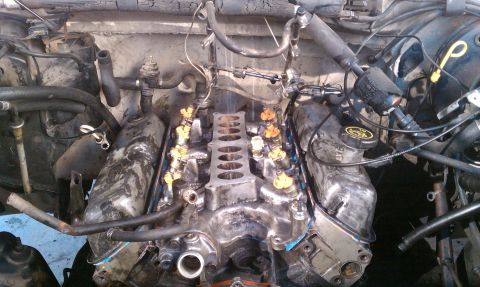 1990 Ford Bronco - Close-up view of engine components, including fuel injectors and intake manifold.