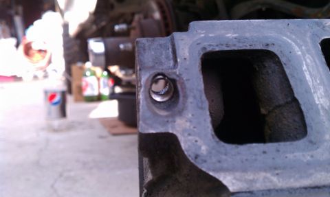 1990 Ford Bronco - Engine intake manifold part shown in detail, with a bolt hole in focus.