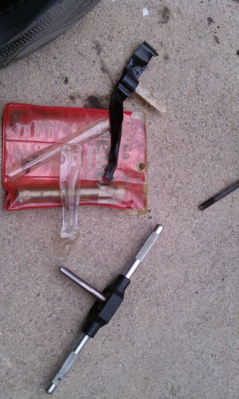 1990 Ford Bronco - A tire repair kit lies on concrete next to a tire tread.