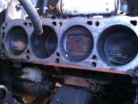 1990 Ford Bronco - Close-up view of an engine block's cylinders and pistons, indicating internal engine components.