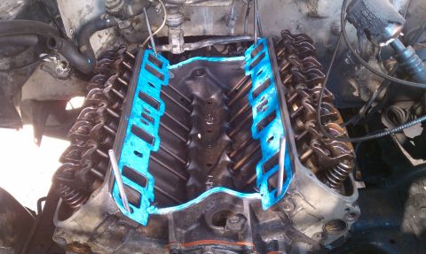 1990 Ford Bronco - Engine intake manifold removed, revealing the valve train and newly installed blue gaskets.