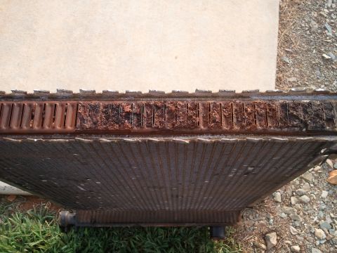 1989 Ford Bronco - This heavily corroded radiator shows significant damage to its fins and top tank, indicating a need for replacement.