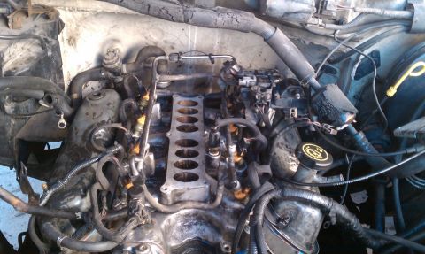 1990 Ford Bronco - Close-up view of a disassembled engine bay, revealing internal components and wiring.