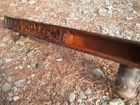 1989 Ford Bronco - This heavily corroded metal beam shows significant rust damage, indicating a need for replacement or extensive repair.