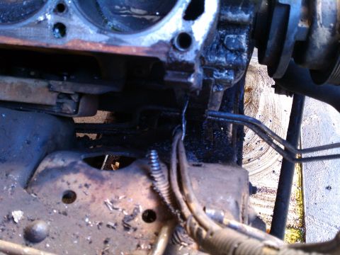 1990 Ford Bronco - This image shows a close-up view of a vehicle's engine block and frame, covered in grease and grime.