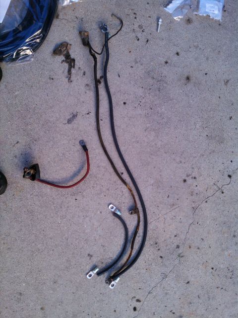 1990 Ford Bronco - Battery cables and wiring harness components are shown on a concrete surface.