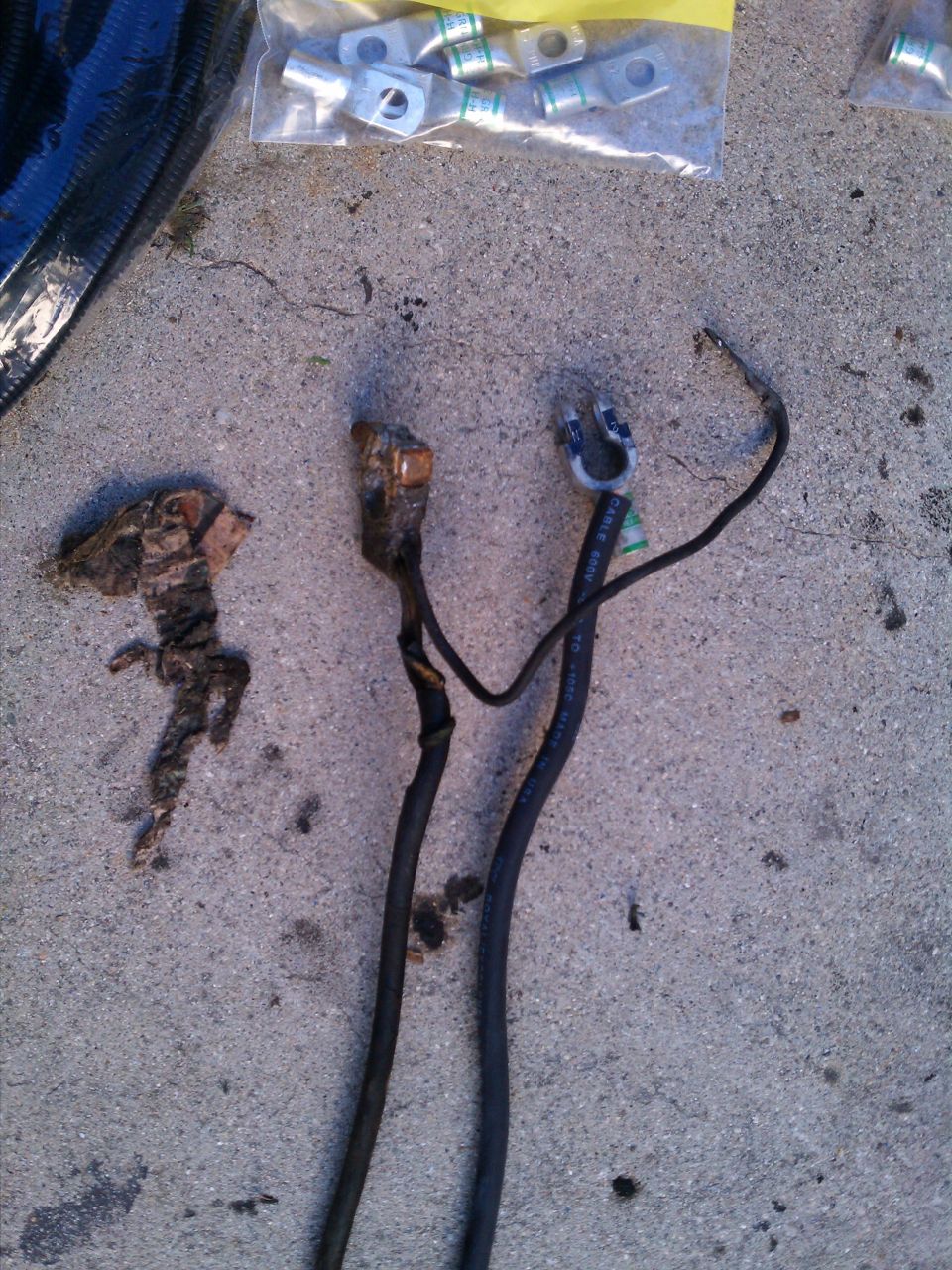 Corroded battery cables and new connectors on concrete