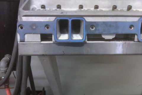 1996 Chevrolet Camaro - A blue gasket is positioned on an engine part, with bolts visible above.
