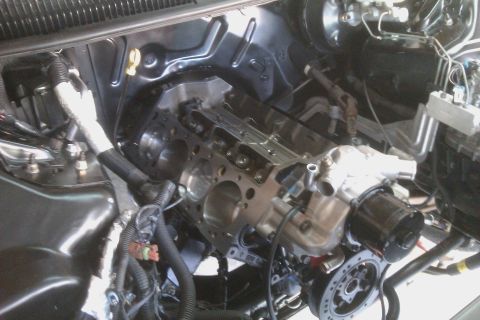 1996 Chevrolet Camaro - The engine bay of a vehicle is shown with the engine partially disassembled, revealing the engine block and various components.