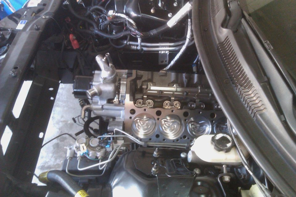 Engine bay with exposed engine block and wiring. Supermotors.net logo visible