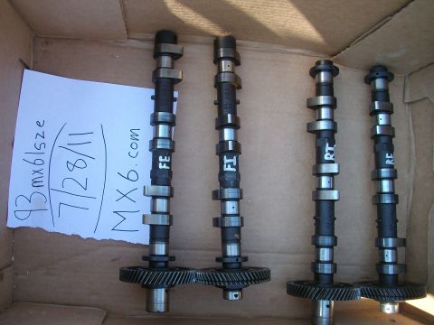 1994 Mazda MX-6 - Camshafts labeled FE, FI, RT, and RE are laid out in a cardboard box with a handwritten note.