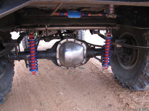 1995 Ford Bronco - Close-up of a vehicle's rear axle and suspension system with custom shocks.