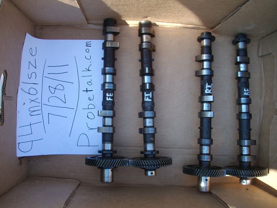 Four camshafts with gears, labeled FE, FI, RT, RE, next to a paper stating '94 mx6/size 7/28/11 probetalk.com'