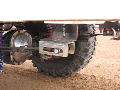 1995 Ford Bronco - This image shows the rear suspension and axle assembly of a vehicle, large tires and aftermarket suspension components.