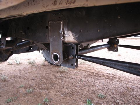 1995 Ford Bronco - Custom suspension components are attached to the frame of a vehicle, with a tire visible in the background.