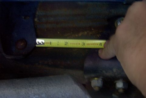 1994 Ford Bronco - A tape measure is used to measure a vehicle suspension component, indicating approximately 3 inches.