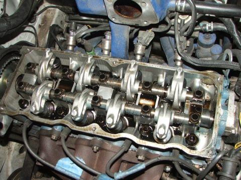 1991 Ford Festiva - Close-up view of an engine's valve train, showing the camshafts and rocker arms with oil present.