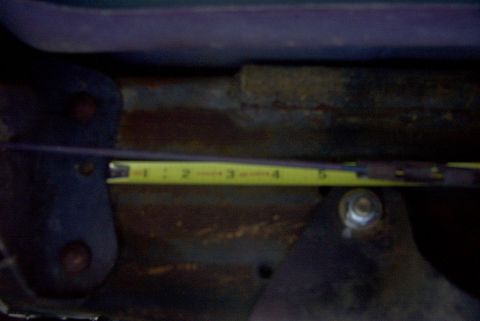 1994 Ford Bronco - Measuring tape is used to measure a rusty metal component, possibly for repair.