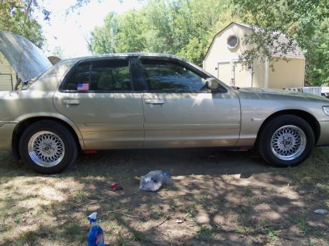 2000 Mercury Grand Marquis - This 2000 Mercury Grand Marquis is shown from the side with its hood open, revealing the engine bay.