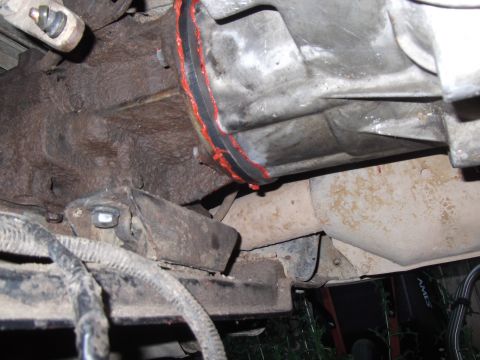 1989 Ford Bronco - This image shows a close-up view of a vehicle's transmission and exhaust system, with visible red sealant around a component.
