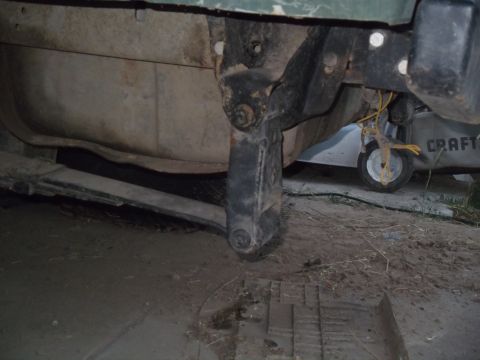 1989 Ford Bronco - Close-up view of a vehicle's undercarriage, revealing mechanical parts and a fuel tank.