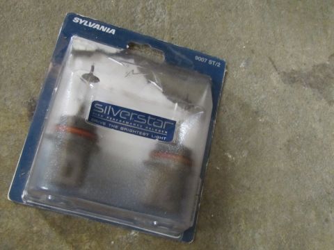 1995 Ford Bronco - Headlight bulbs are packaged for sale, with brand and product information visible on the packaging.