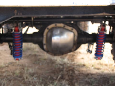 1995 Ford Bronco - Close-up of a rear differential with aftermarket red and blue shocks visible.