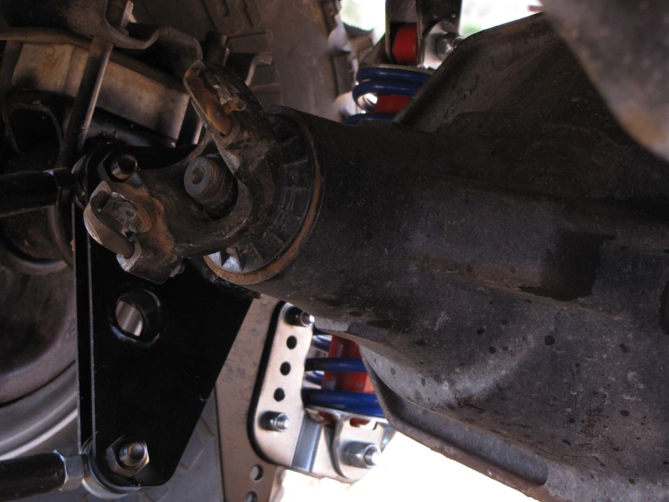 Rear axle assembly with U-joint, shock absorber, and suspension linkage