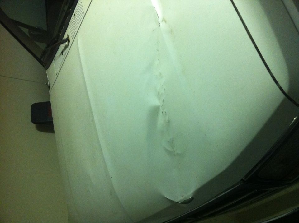 White SUV fender with significant damage. 1996 Ford Bronco