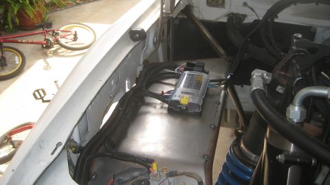 1996 Ford Bronco - Close-up view of the engine bay, focusing on the fuse box and wiring harness, with visible blue springs.