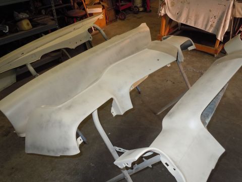1970 Chevrolet Camaro - Unidentified car body parts, possibly fenders and bumpers, are displayed on stands in a workshop.