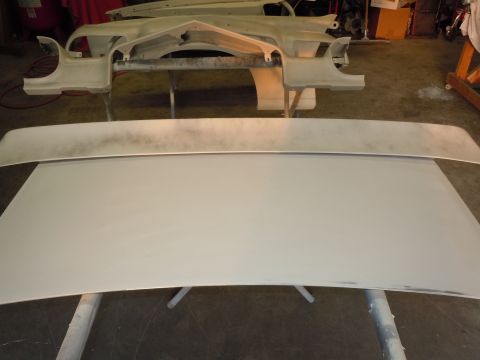 1970 Chevrolet Camaro - Car body parts, likely for restoration, are laid out on stands in a workshop setting.