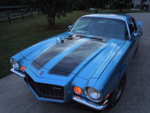 1972 Chevrolet Camaro - A blue 1970 Chevrolet Camaro Z28 with dual black racing stripes on the hood is parked outdoors.