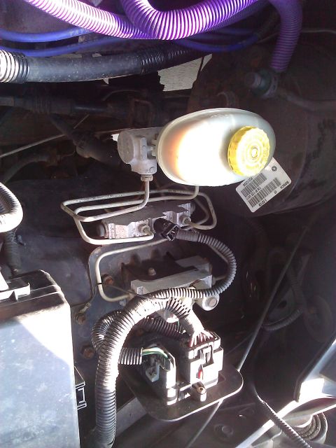 2007 Dodge Durango - Close-up view of the brake fluid reservoir and master cylinder assembly, showing various hoses and electrical connections.