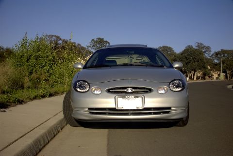 1998 Ford Taurus - A silver 1998 Ford Taurus is parked curbside on a sunny day.