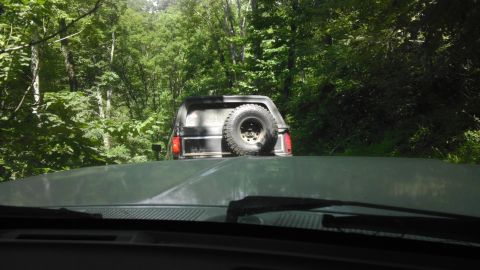 1989 Ford Bronco - Following a Ford Bronco on a wooded trail during the day.