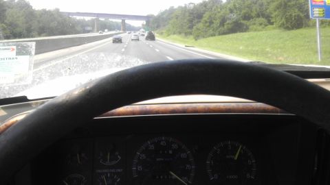 1989 Ford Bronco - View from inside a 1989 Ford Bronco on the highway, showing the dashboard and steering wheel.